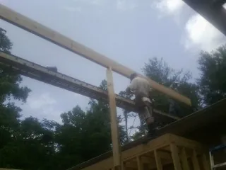 Carpenter setting a ridge beam over a new addition frame — Ice Dam Removal by Roofing Brothers in Bridgton