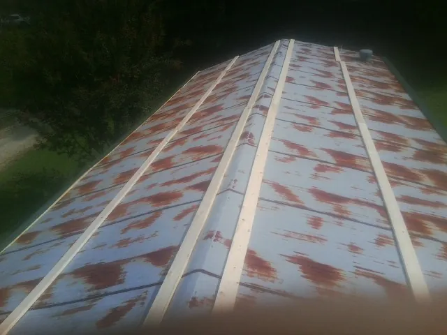 Rusted metal roof panels with new wood purlins before replacement — Storm Damage Roof Repair in Bridgton by Roofing Brothers