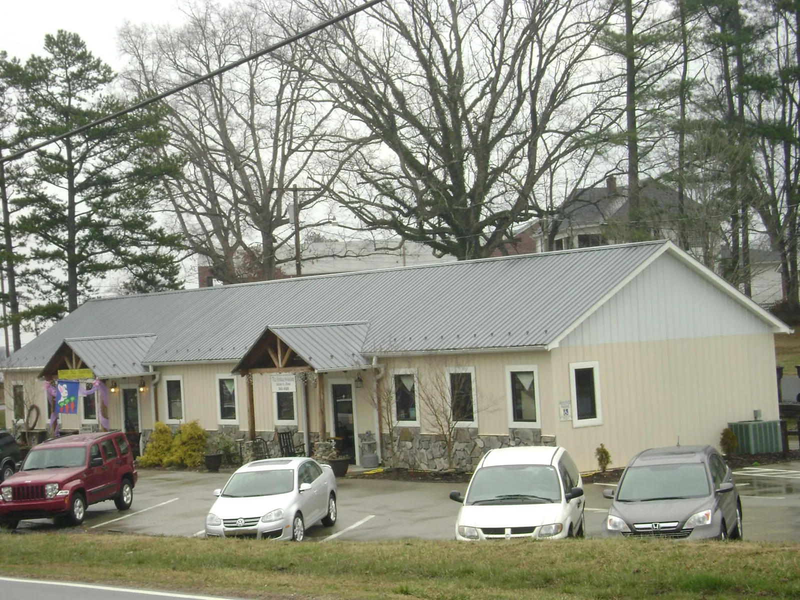 Gray metal roof with timber entry brackets on a small commercial building in Bridgton